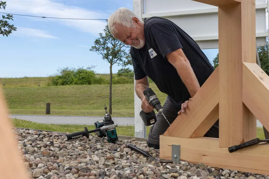 Handwerker montiert eine Holztreppe auf dem Gelände des Strandhaus Ahrenshoop.