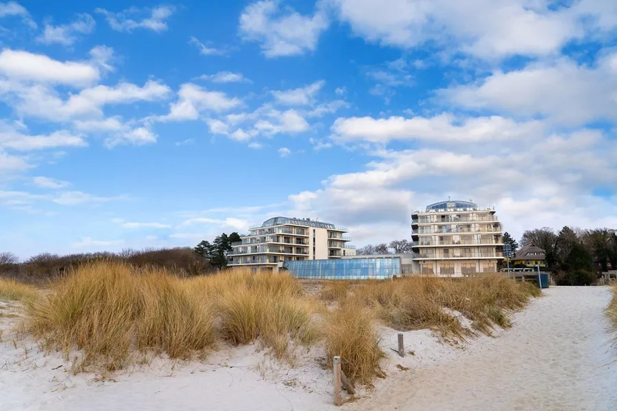 Aussenansicht von THE GRAND Ahrenshoop hinter Duenengraesern am Ostseestrand auf dem Fischland-Darß.