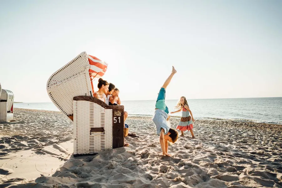 Familie am Strandkorb an der Ostsee auf dem Fischland-Darß, Kinder spielen im Sand im Sommer.